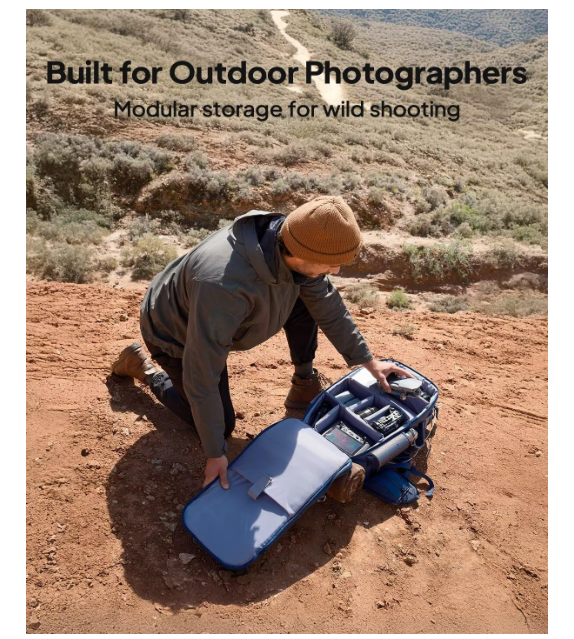 Outdoor photographer organizing camera gear in modular backpack on a scenic hilltop.