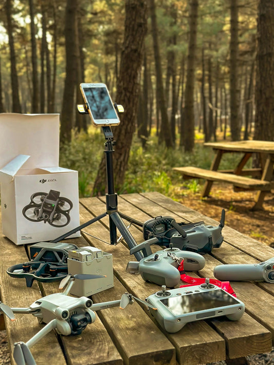 DJI drones, controllers, and accessories on picnic table in forest, solar power solutions context