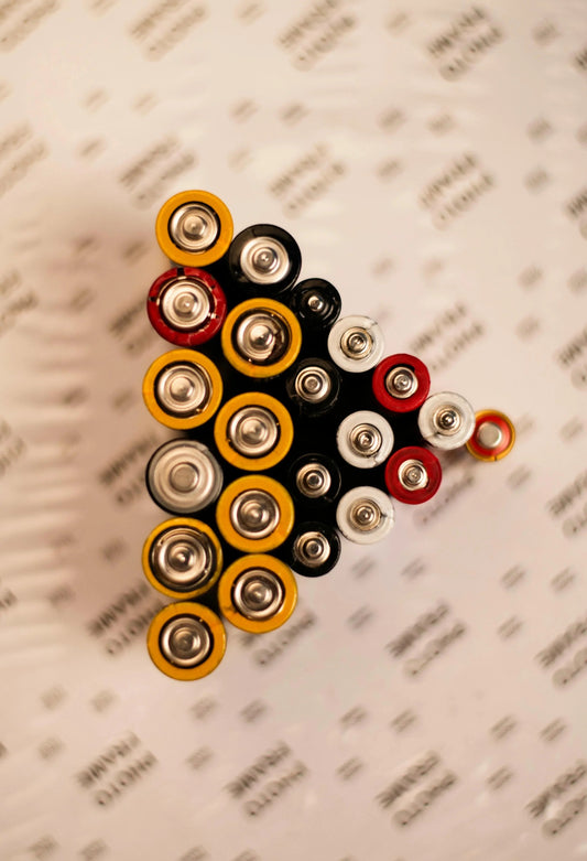 Top view of assorted AA batteries on a blurred SolarFlare Generators branded surface.