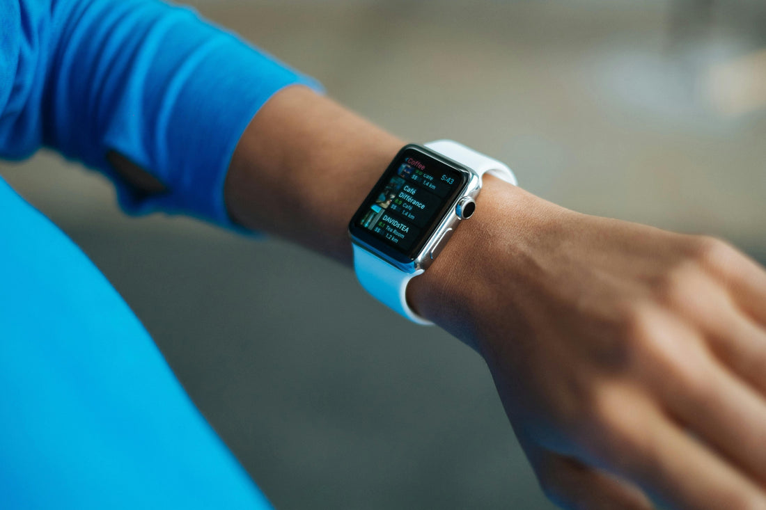 Close-up of a smart watch with white band on a person’s wrist displaying app list