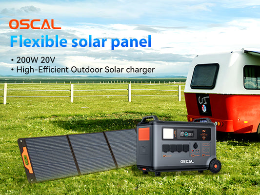 Flexible solar panel and portable generator for outdoor use near a camper trailer on grass