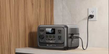 Portable power station BLUETTI Elite 30 V2 in gray, featuring a display, multiple output ports, and connected to an outlet.