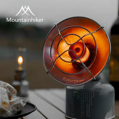 Portable stove with flame on a blurred outdoor background, featuring the Mountainhiker brand.