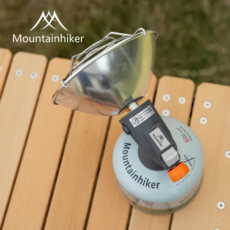 Portable camping stove with fuel canister on a wooden surface, featuring the Mountainhiker brand.