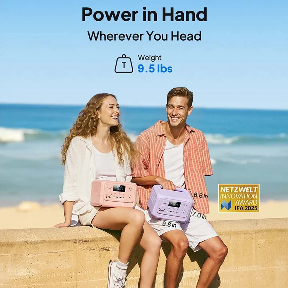 Couple sitting on a beach wall, each holding a compact BLUETTI Elite 30 V2 Portable Power Station in pink and purple.