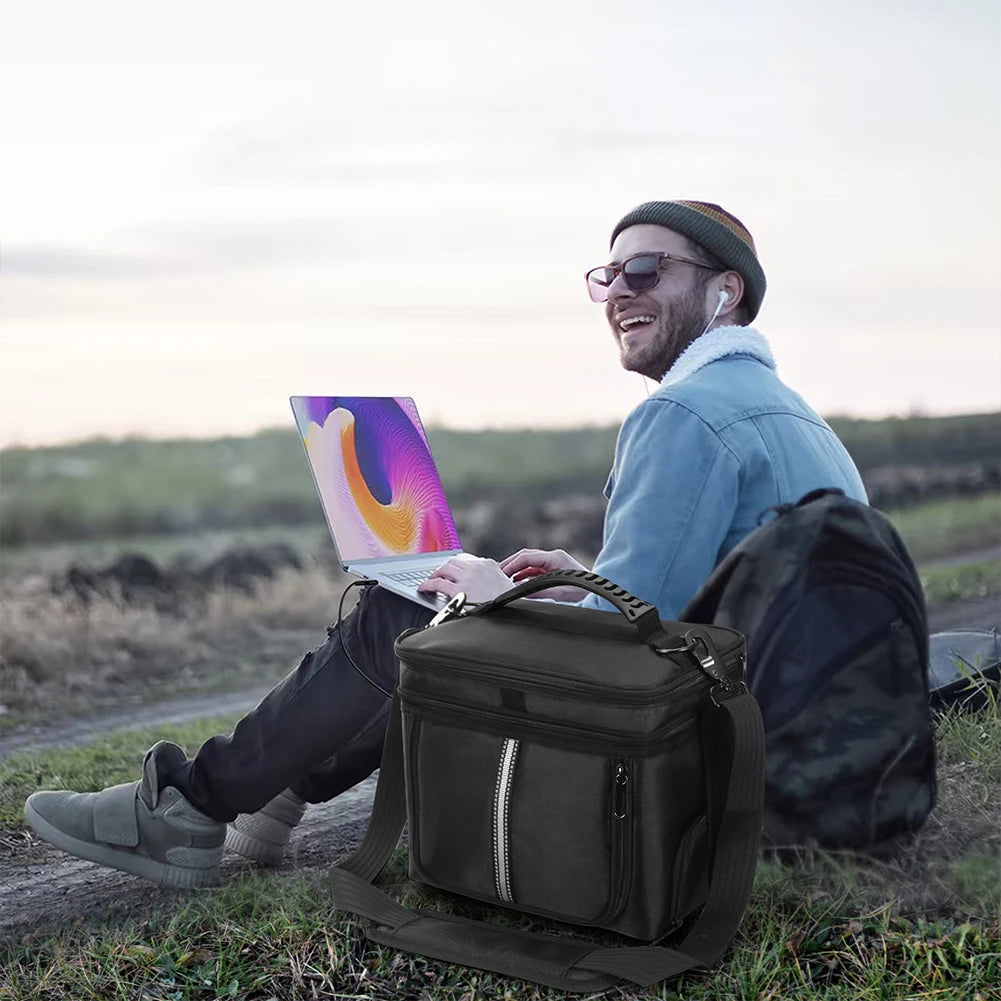 Black carrying case for BLUETTI EB3A power station, featuring a handle and adjustable strap, placed beside a user on the grass.