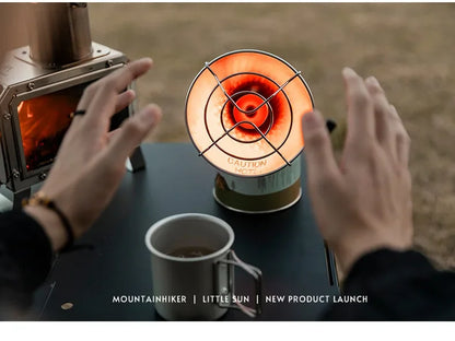 Person holding a cup of coffee near a small lamp with 'Mountainhiker' branding.