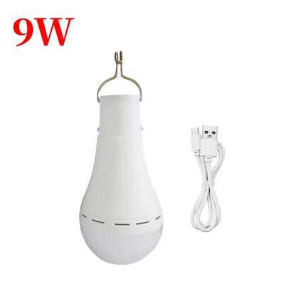 Rechargeable solar camping light in white with a hook and USB charging cable for portable use.