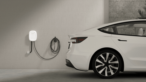 Home EV charger for Tesla mounted on garage wall, promoting renewable energy solutions
