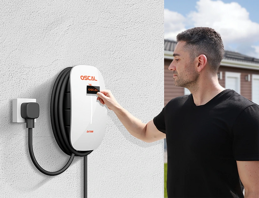 Man using wall-mounted EV charger outdoors, plugging in electric vehicle charging station